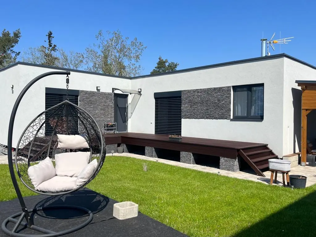 Moderní bungalov Hradec Králové s plochou střechou, kamenným obkladem a dřevěnou terasou