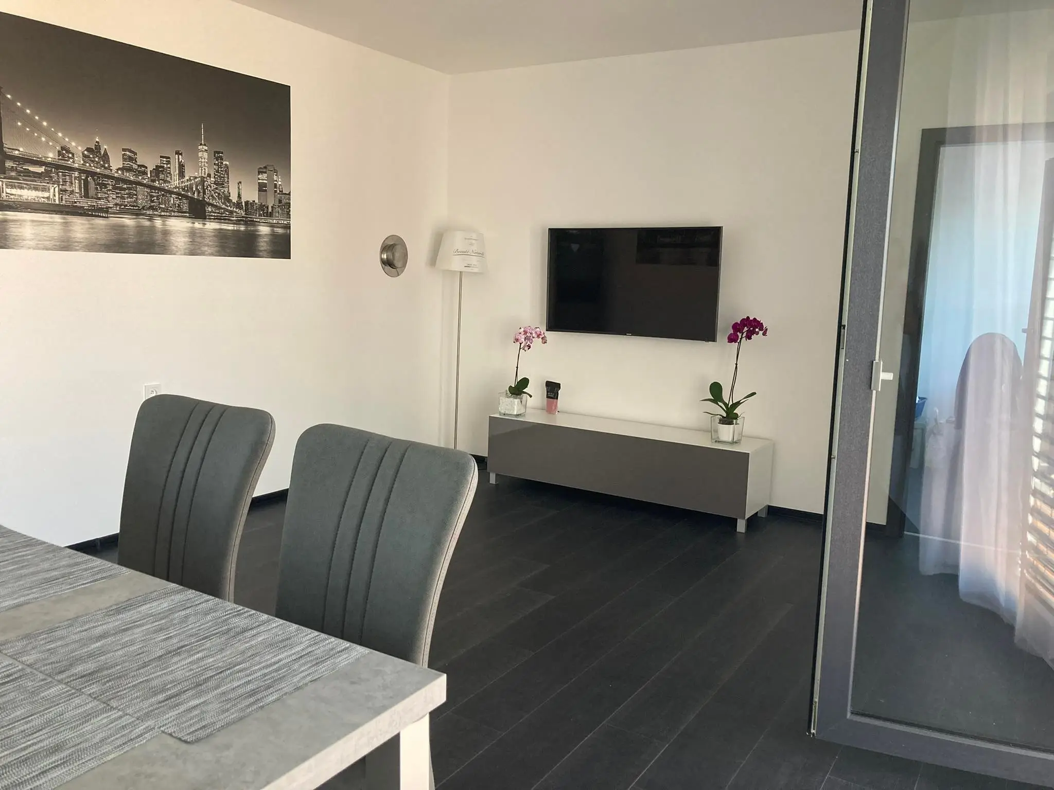 Obývací pokoj s televizí a fototapetou panoramatu New Yorku v modulovém bungalovu Hradec Králové