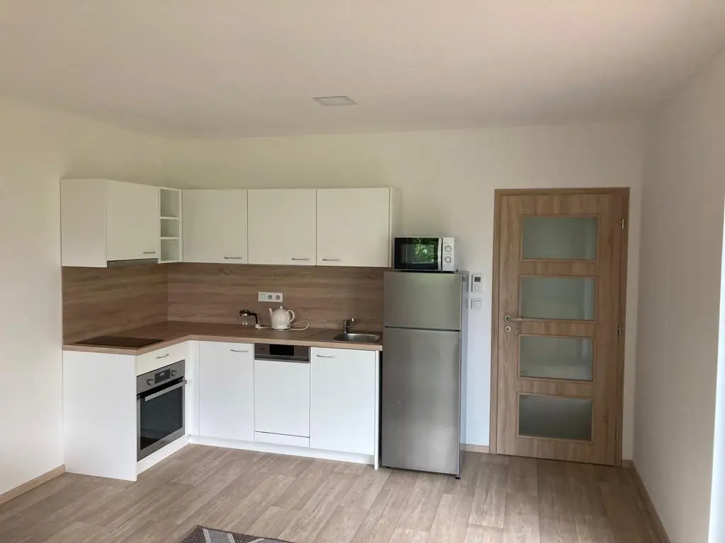 Pohled do kuchyně se vstupem do chodby v interiéru modulového bungalovu Pardubice