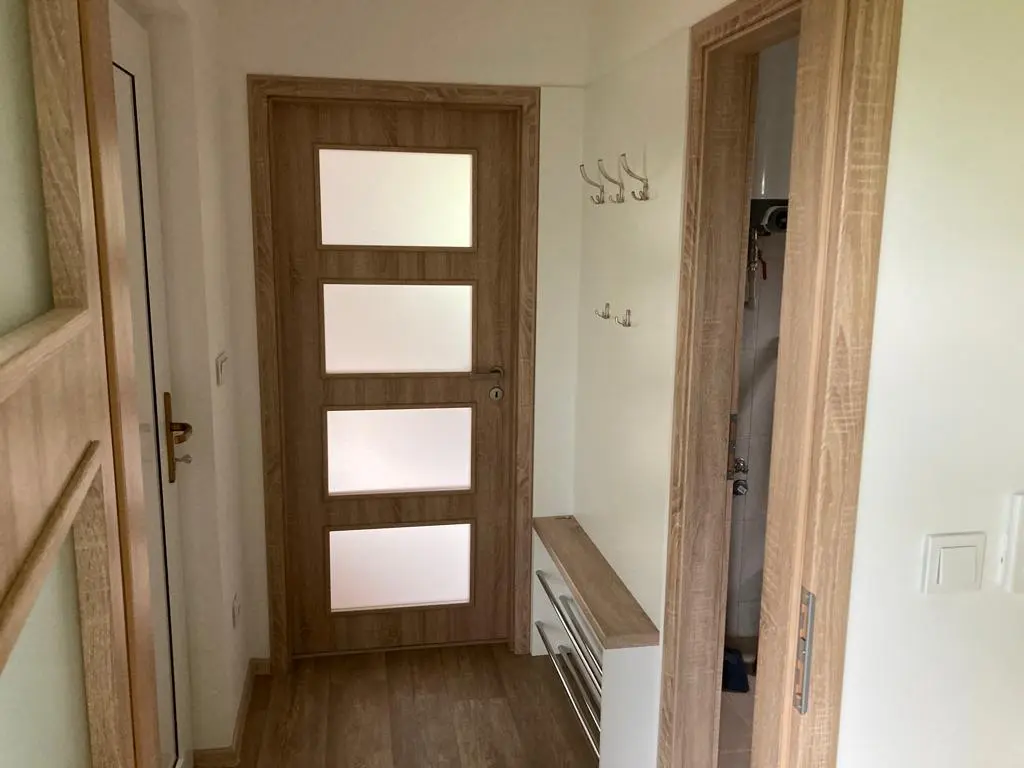Chodba s vestavěným věšákem u vchodových dveří modulového domu Pardubice