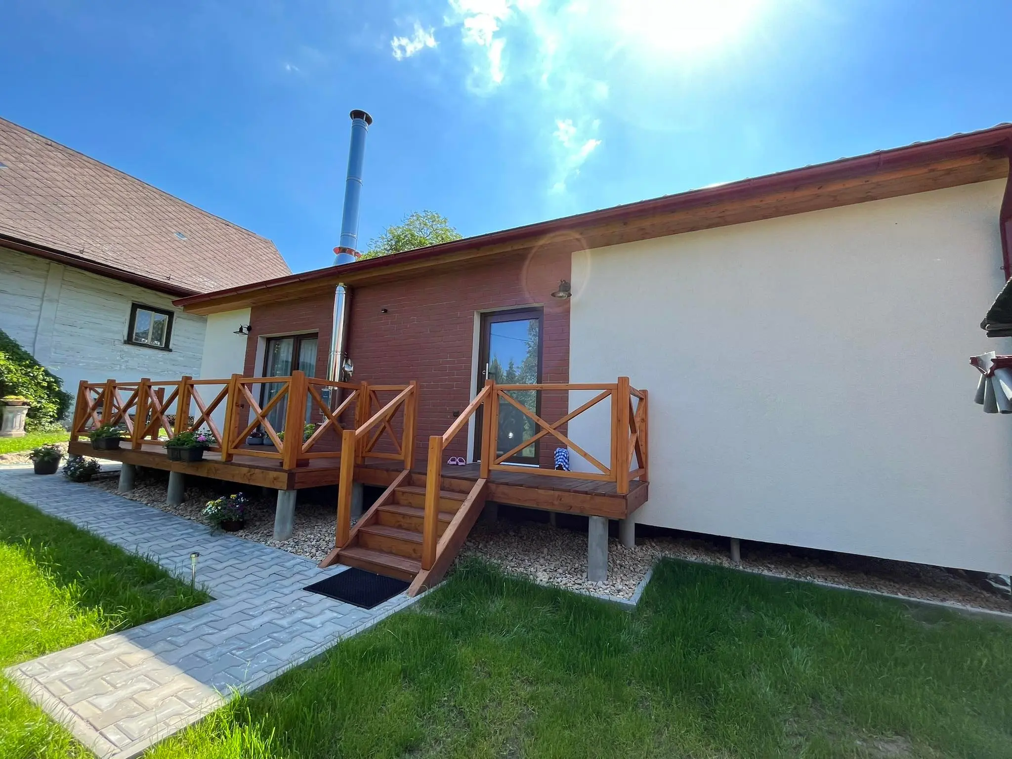 Modulový bungalov Solnice s bílou omítkou, dřevěným obkladem a verandou se schody